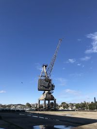 Crane at construction site against blue sky