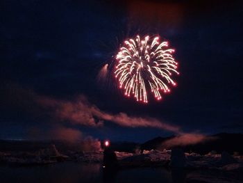 Low angle view of firework display at night