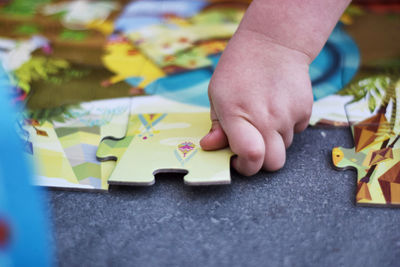 Close-up of baby hand holding multi colored paper