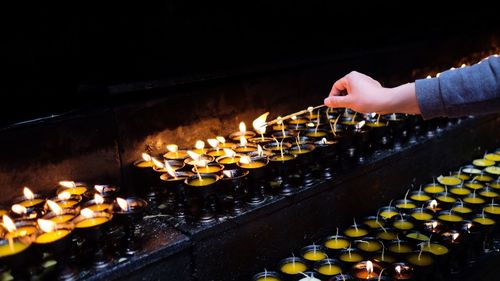 Cropped hand of woman burning incense with diya at jokhang temple