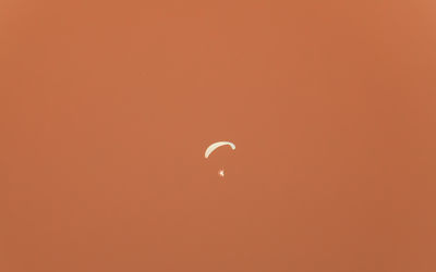 Low angle view of moon against orange sky