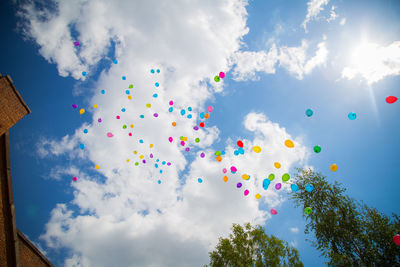 Low angle view of balloons flying against sky