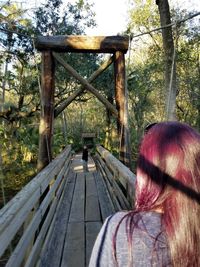 Rear view of woman on tree against sky