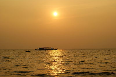 Boat in sea at sunset