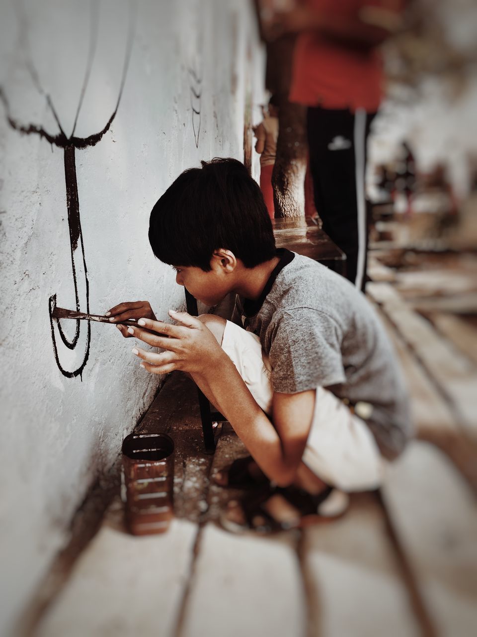 lifestyles, leisure activity, childhood, holding, casual clothing, indoors, full length, person, sitting, wood - material, boys, elementary age, working, selective focus, occupation, three quarter length, men