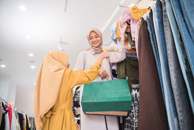 Smiling mother with daughter in clothing store