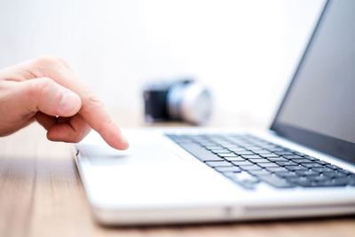 Midsection of person using mobile phone on table