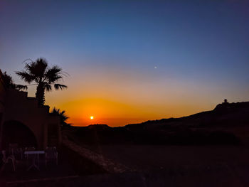 Scenic view of silhouette landscape against clear sky during sunset