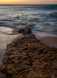 Scenic view of beach against sky during sunset