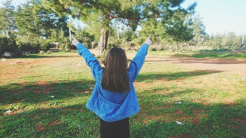Rear view of woman on field against sky