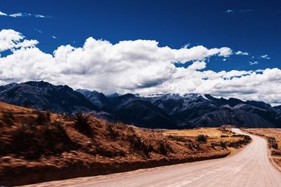 Road amidst snowcapped mountains against sky