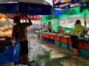 Rear view of people standing at market