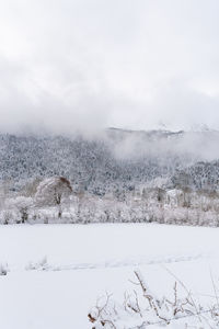 Snow covered field against sky