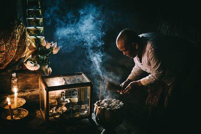 Side view of man preparing food