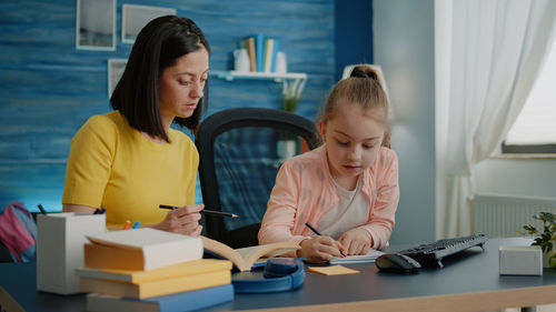 Mother assisting daughter in studies