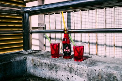 Red bottles on table by window in building