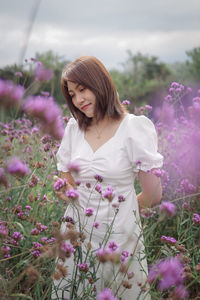 Young woman standing amidst flowers