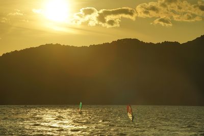 People windsurfing against the background of the setting sun over biwako lake