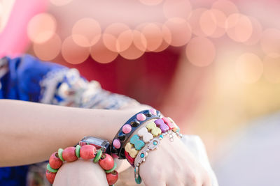 Midsection of woman wearing colorful bracelets