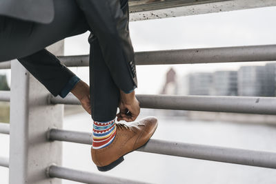 Young businessman tying shoe laces