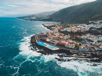 High angle view of sea and buildings against sky