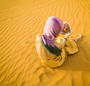 Woman looking in a mirror in the middle of the moroccan desert ii