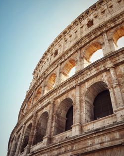 Low angle view of historic colosseum arch windows against sky