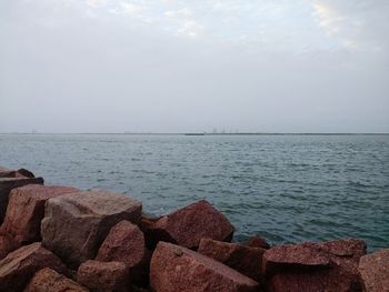 Scenic view of rocks in sea against sky