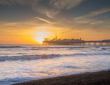 Pier on sea at sunset