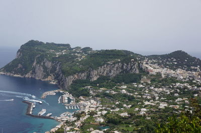 Scenic view of sea by mountains against clear sky