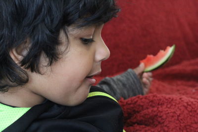 Close-up of cute boy holding watermelon slice
