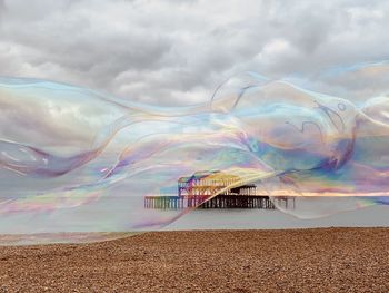 Scenic view of sea against rainbow in sky