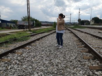 Rear view of man standing on railroad track