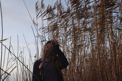 Couple standing by plants against sky