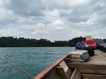 Rear view of man sitting on pier against sky