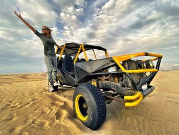 Full length of woman standing on beach buggy at desert