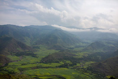 Scenic view of valley and mountains against sky