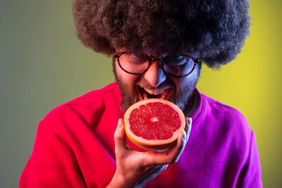 Close-up of man holding orange fruit
