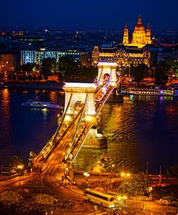 Illuminated bridge over river at night