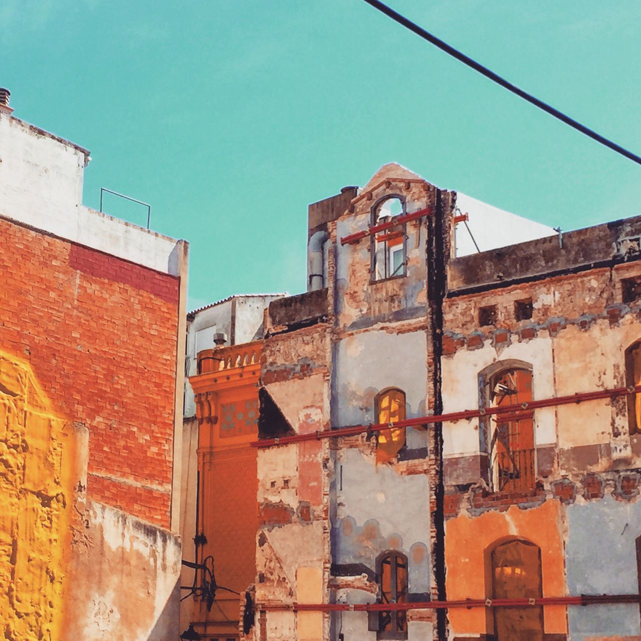 building exterior, architecture, built structure, clear sky, low angle view, old, residential structure, church, house, blue, window, building, sky, outdoors, residential building, no people, day, weathered, sunlight, history