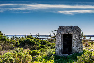 Abandoned built structure on field against sky