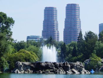 Fountain in front of waterfall against sky