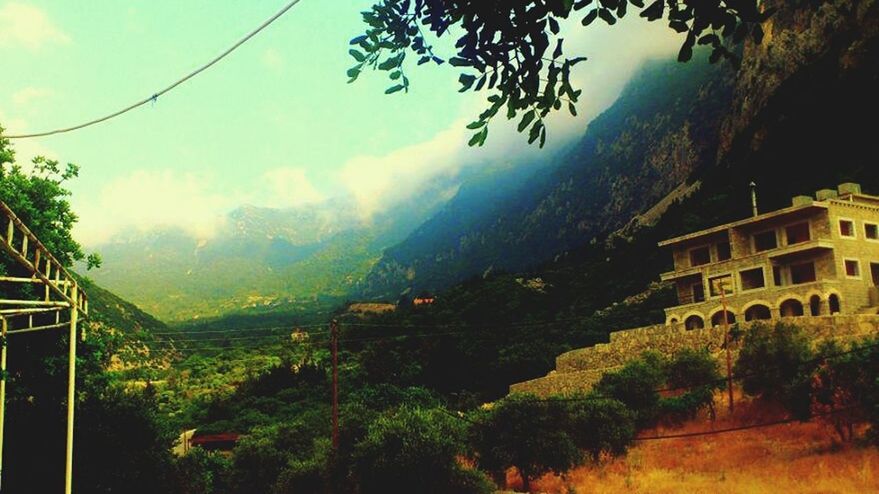 mountain, tree, sky, architecture, built structure, building exterior, mountain range, scenics, nature, beauty in nature, house, tranquility, tranquil scene, cloud - sky, green color, landscape, growth, cloud, day, residential structure