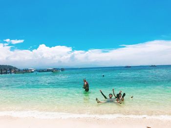 People on beach against blue sky