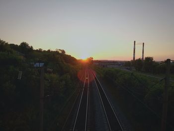 Railroad tracks against sky during sunset