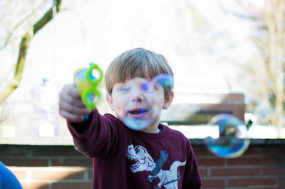 Boy playing with bubbles at yard