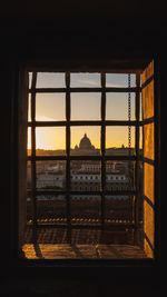 Buildings seen through window during sunset