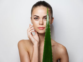 Portrait of young woman against white background