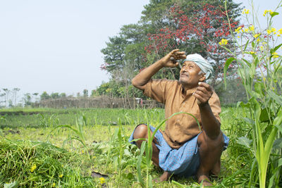 Indian farmer looking at sky 