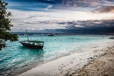 Boat moored on sea against sky